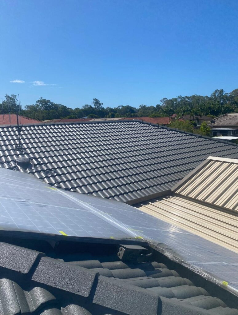 Recently painted tile roof showcasing precision work around wrapped solar panels